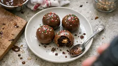 Palline di Natale al cacao con cuore di crema di nocciole: ricetta facile e scenografica